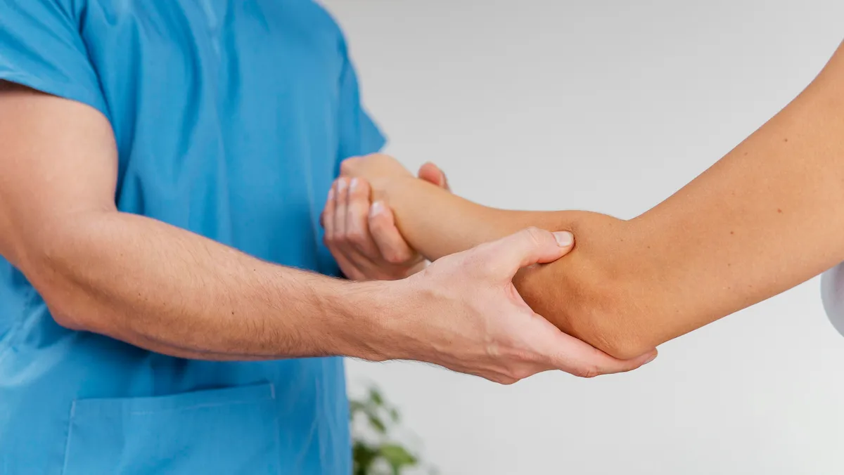 osteopathic-therapist-checking-female-patients-elbow-joint-movement